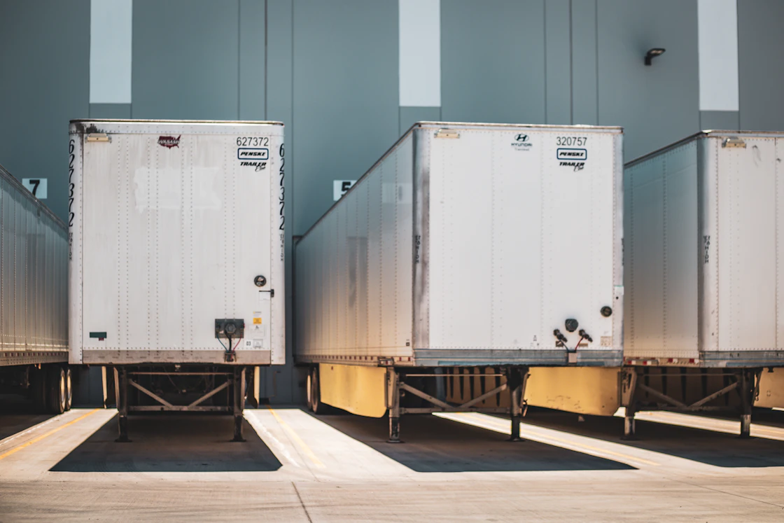 Dry van trailers backed up to warehouse loading dock doors
